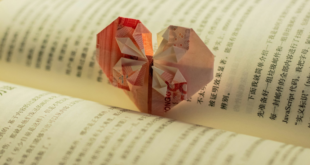 An origami heart nestled in the open spine of a book